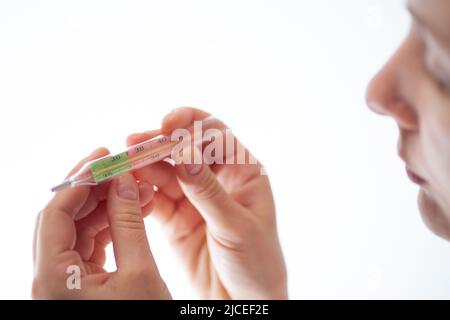 the girl measures the temperature during chills and coughs because she has a new coronavirus infection Stock Photo