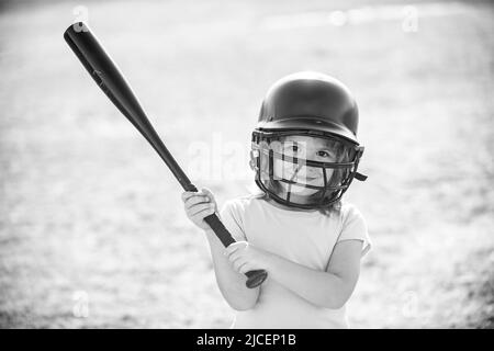 Little child baseball player focused ready to bat. Kid holding a baseball bat. Stock Photo