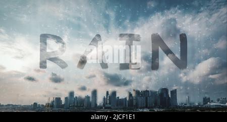 Rain drops on glass with city background. Window view with raining outside. Drops on glass and bokeh from city. Out of focus cityscape behind the wind Stock Photo