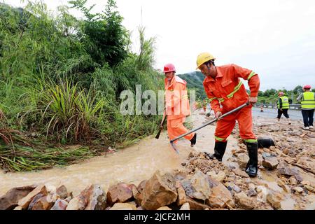 LIUZHOU, CHINA - JUNE 13, 2022 - Highway emergency repair workers clear mudslides on the Sanliu Expressway in Liuzhou city, South China's Guangxi Zhua Stock Photo