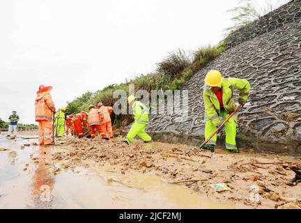 LIUZHOU, CHINA - JUNE 13, 2022 - Highway emergency repair workers clear mudslides on the Sanliu Expressway in Liuzhou city, South China's Guangxi Zhua Stock Photo
