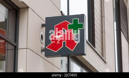 Stuttgart, Germany - Nov 16, 2021: Close up view on German apothecary and green cross sign. Indicating presence of a pharmacy. Place to buy medicine, Stock Photo