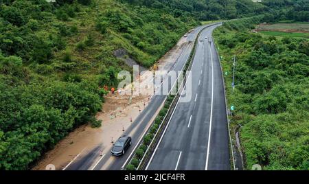 LIUZHOU, CHINA - JUNE 13, 2022 - Highway emergency repair workers clear mudslides on the Sanliu Expressway in Liuzhou city, South China's Guangxi Zhua Stock Photo