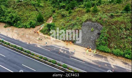 LIUZHOU, CHINA - JUNE 13, 2022 - Highway emergency repair workers clear mudslides on the Sanliu Expressway in Liuzhou city, South China's Guangxi Zhua Stock Photo