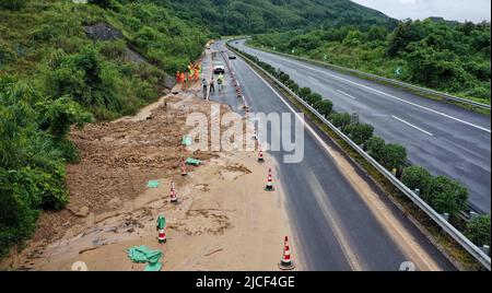 LIUZHOU, CHINA - JUNE 13, 2022 - Highway emergency repair workers clear mudslides on the Sanliu Expressway in Liuzhou city, South China's Guangxi Zhua Stock Photo