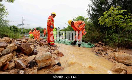 LIUZHOU, CHINA - JUNE 13, 2022 - Highway emergency repair workers clear mudslides on the Sanliu Expressway in Liuzhou city, South China's Guangxi Zhua Stock Photo