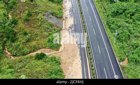 LIUZHOU, CHINA - JUNE 13, 2022 - Highway emergency repair workers clear mudslides on the Sanliu Expressway in Liuzhou city, South China's Guangxi Zhua Stock Photo