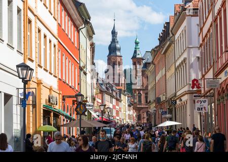 Heidelberg, Germany - Aug 25, 2021: View along the pedestrian zone of Heidelberg. In the background the steeple of the Church of the Holy Spirit. Stock Photo