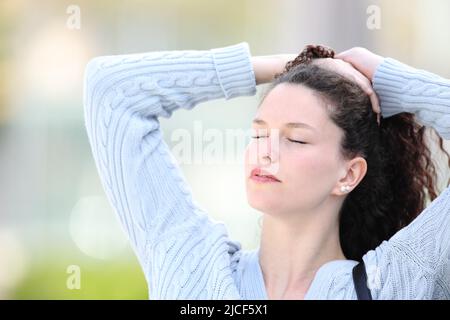 Woman standing in the street doing ponytail Stock Photo