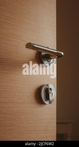 Modern metallic door handle on medium density fiberboard bedroom door, selective focus Stock Photo