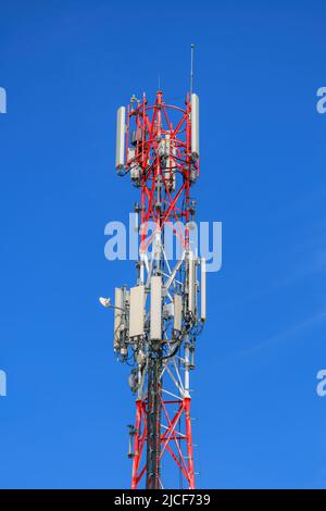 Telecommunication pylon with signal repeaters and antennas against blue sky for wireless technology and broadcasting industry concept, copy space incl Stock Photo