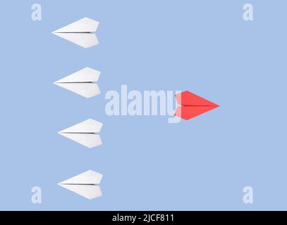 White origami planes with outstanding red one flying in the opposite direction on blue background. New idea, creativity, individuality, freedom, standing out from crowd concept. High quality photo Stock Photo