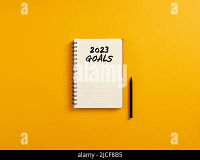 Notepad and black pen on yellow background with the word year 2023 goals. 2023 personal or business planning. Stock Photo