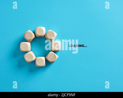 Wooden cubes with the word loading in loading progress indicator bar. Stock Photo