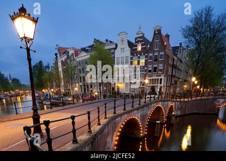 Historic buildings and bridges along Keizersgracht Canal at dusk, Amsterdam, North Holland, Netherlands Stock Photo