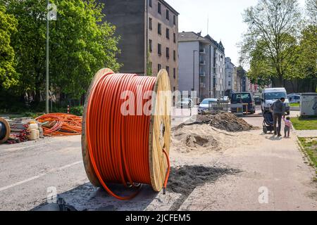 Duisburg, North Rhine-Westphalia, Germany - Internet broadband expansion, construction site laying of fiber optic cable, cable drum with fiber optic cable, new construction of fiber optic routes, fast Internet, DSL cable connection for households. Stock Photo