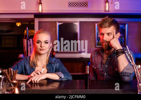 A man and woman smoking electronic cigarette in a vape bar. Stock Photo