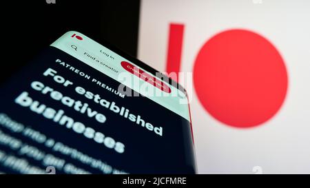 Mobile phone with webpage of US membership platform company Patreon Inc. on screen in front of business logo. Focus on top-left of phone display. Stock Photo