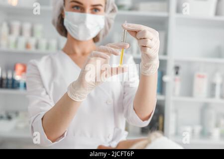 Portrait of professional female beautician holding a syringe with botox ready for injection Stock Photo