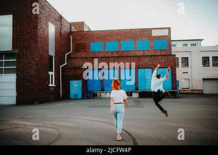 happy young couple, man jumping in the air, back view Stock Photo