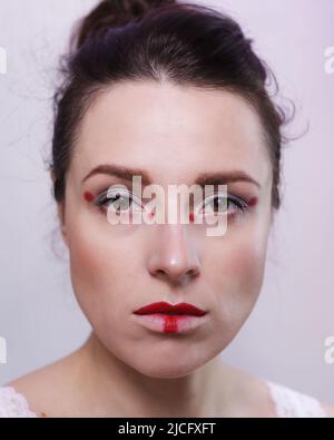 Portrait of a woman wearing sci-fi movie inspired makeup in red and silver colors Stock Photo