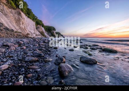 On the rocky beach of Kiel shore on the island of Rügen in Jasmund National Park at sunrise with a view of the chalk coast Stock Photo