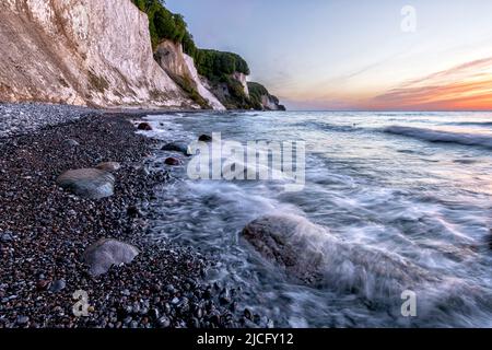 On the rocky beach of Kiel shore on the island of Rügen in Jasmund National Park at sunrise with a view of the chalk coast Stock Photo