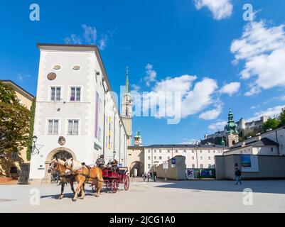 Salzburg, Franziskanerkirche (Franciscan Church), Stiftskirche St. Peter (Collegiate Church of St. Peter) right, fiaker horse cab, Hohensalzburg Castle in Flachgau, Salzburg, Austria Stock Photo