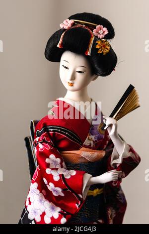 Close-up portrait of Japanese geisha doll in traditional costume, illustrative of typical geisha appearance Stock Photo