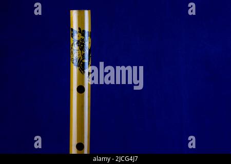 Closeup view of chinese bamboo flute isolated on a blue background Stock Photo