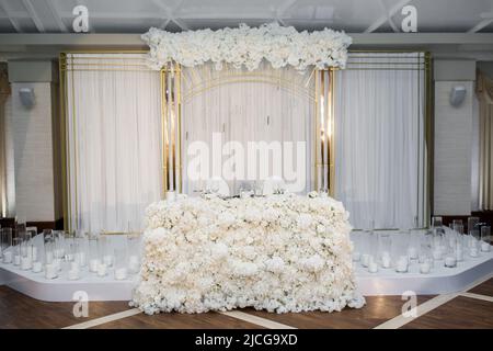 Arch for an outdoor wedding ceremony in white hall. Stock Photo