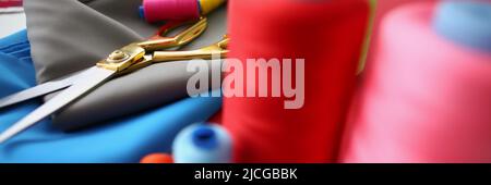 Composition of sewing accessories scissors and threads on fabric Stock Photo
