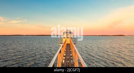 Sunset over Dutch national park Lauwersmeer in Friesland with an ancient lighthouse in front Stock Photo