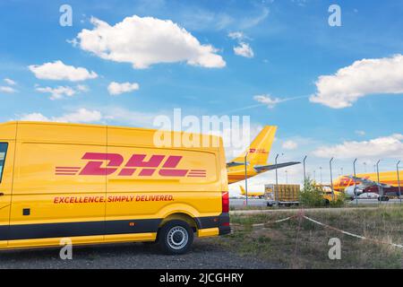 Schkeuditz, Germany - 29th May, 2022 - Many courier van against cargo planes parked on Leipzig Halle airport terminal apron for loading distribution Stock Photo