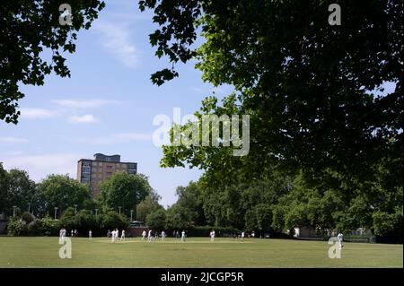 London, Hackney. London Fields. Cricket game underway. Stock Photo