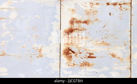 Scratched surface of panels with paint and rust stains. Metal material with streaks of rust. Texture of the old rusty metal sheet. Corroded painted ir Stock Photo