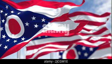 The Ohio state flag waving along with the national flag of the United States of America. In the background there is a clear sky. Ohio is a state in th Stock Photo