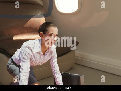 Composite image of caucasian businesswoman with a suitcase against airplane window in background Stock Photo