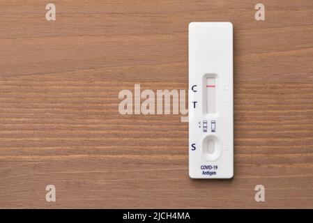 Top view of rapid COVID-19 antigen self test with negative result on wooden background Stock Photo