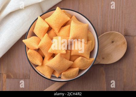 Top view  of wheat cereal pillows in ceramic bowl on wooden table Stock Photo