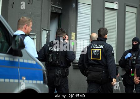 Euskirchen, Germany. 13th June, 2022. Police officers stand in the entrance of a house. Numerous police officers search various objets for drugs in the city center. Credit: Federico Gambarini/dpa/Alamy Live News Stock Photo