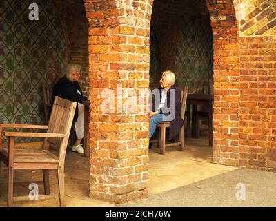 london08-04 2017.two elderly ladies chat amiably on the porch of a public park in London, even though they seem  to be separated by a brick column Stock Photo