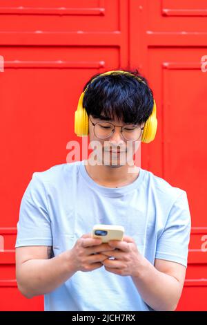 asian man using his smartphone to listen to music Stock Photo