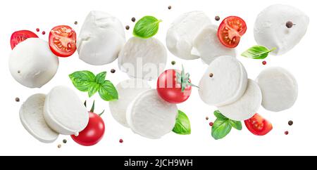 Flying slices of mozzarella cheese with cherry tomatoes, pepper and basil isolated on white background. The concept of organic food products for Medit Stock Photo