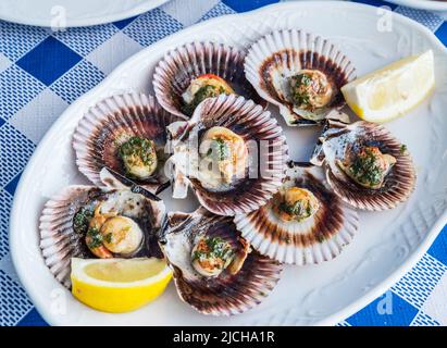 'Lapas' or true limpets with green moyo - traditional seafood of Tenerife and Madeira Islands. Stock Photo