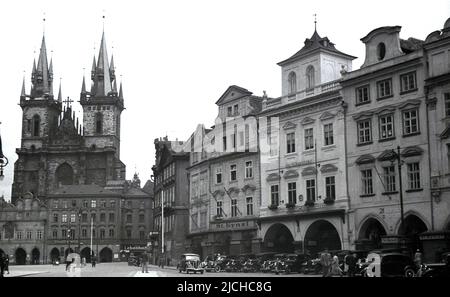 1934, historical view of the market square in the old town of Prague, Czechoslovakia, showing cars of the era and buildings. Picture shows the 14th century gothic Church of Our Lady before Tyn, also known as the Church of Mother of God before Tyn, Stock Photo