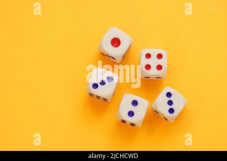 Five dice with different numbers on a orange sunny table. Stock Photo