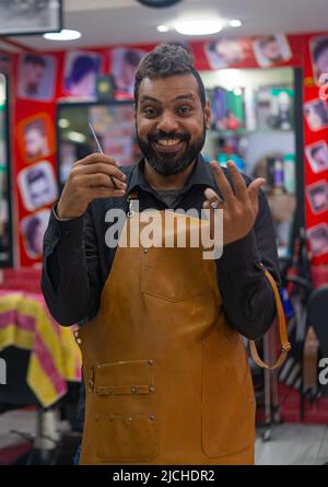 Happy barber arab man portrait with scissors Stock Photo