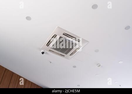Modern ceiling cassette air conditioning system with video surveillance camera, ceiling spotlights Stock Photo