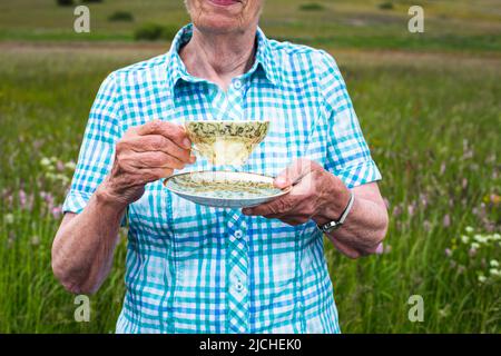 close-up of older woman holding a tea cup Stock Photo